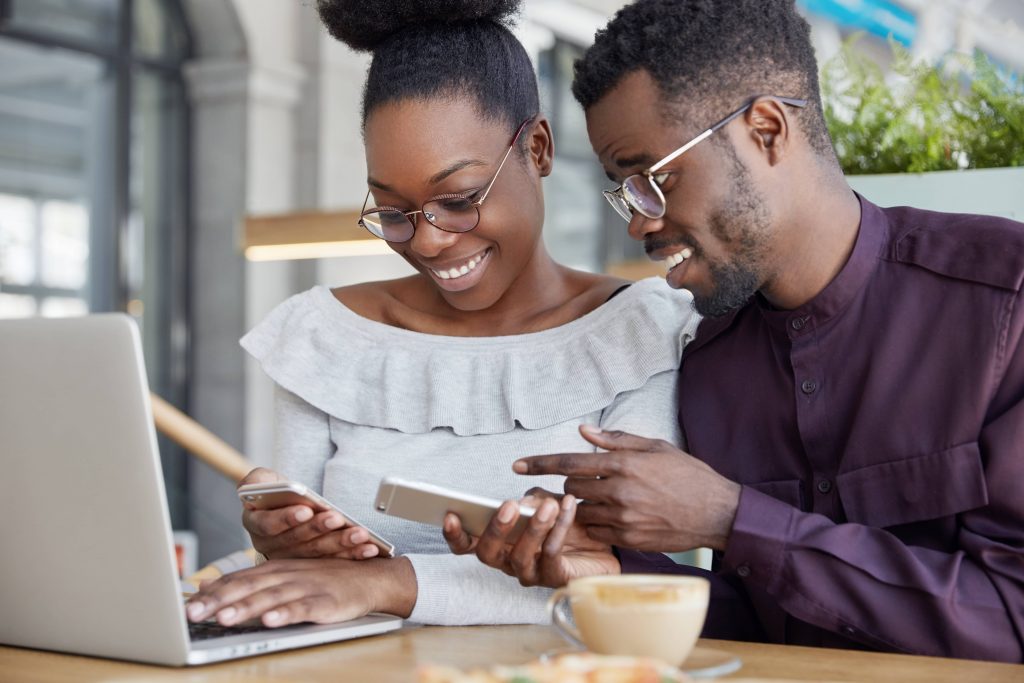 black-woman-man-have-informal-meeting-glad-view-photos-smart-phone-wear-spectacles-work-together-common-project-via-laptop-computer-min-1024x683